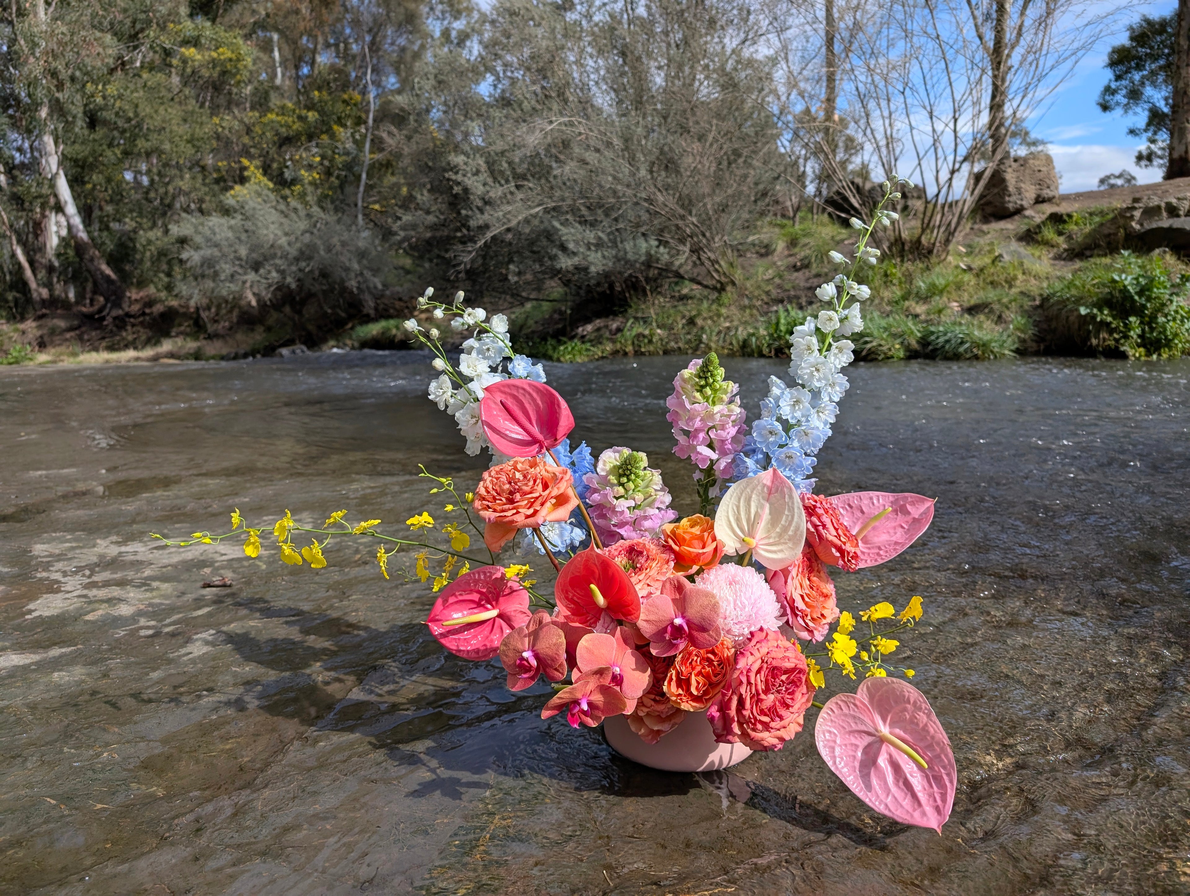 Bright flower arrangement sitting on a creek bed in Coburg made by our Melbourne Florist.